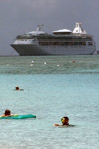 cropped picture of swimmers with ship in background