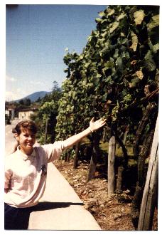 Penny, standing in the street of Cugnasco, admires a bunch of grapes