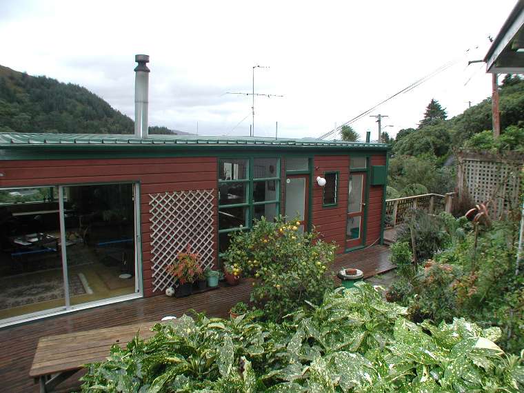 This is the real estate agent's photo looking down from the road onto my back deck.  The furnishings inside have changed, but the rest of  it lis still the same  1970s brown and green. with lots of windows and the view from the front windows south to the harbour mouth.  The corner of roof at top right is my carport.
