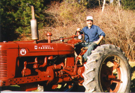 Mike Sloane sitting on his Farmall Super M tractor