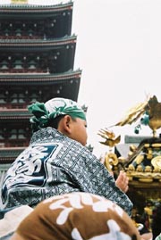 A Kid All Ready To Carry 2 Tonnes.  Note The Pagoda In The Background