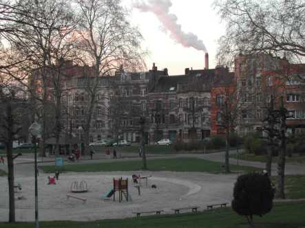 Parque en Bruselas (Bélgica) con, al fondo, la chimenea del incinerador de basura.