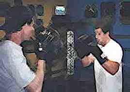 Boxing instruction by coach with focus mitts.  Image Copyright (c) 1999.  All Rights Reserved