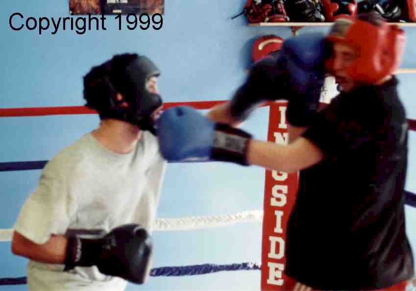 The second boxer rotates into the sparring.  Here, he block the left, while countering to the boxer who has dropped his guard.  Image copyright 1999.  All rights reserved.