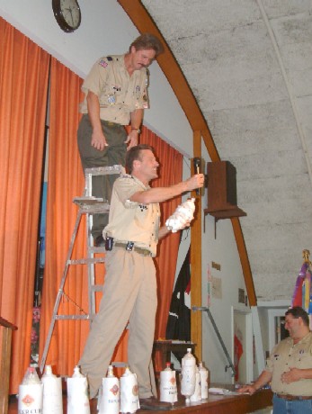Asst Cubmaster climbs the ladder to drop a Den's egg