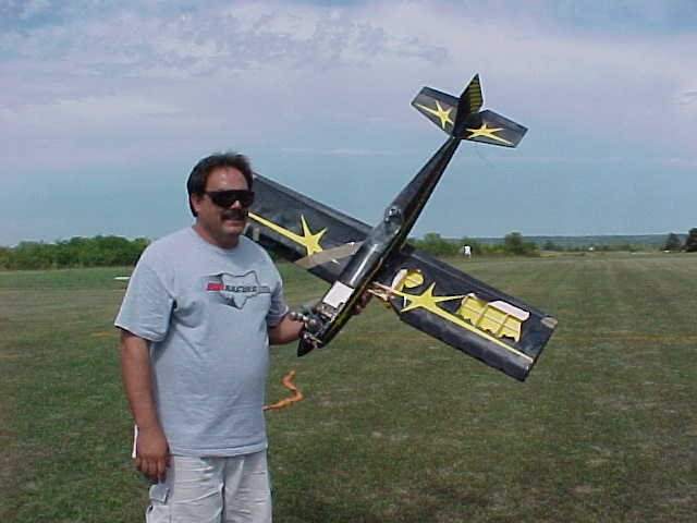 Tony Holladay caries his airplane back to the pits after the midair collision with Steve