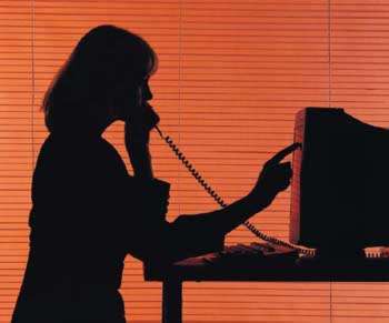 silhouette of woman reading from computer