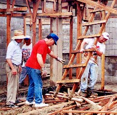 Three men working with a make-shift ladder