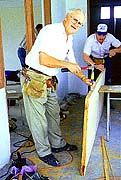Bob Macy works on a door