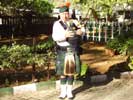Bill tuning his bagpipes in the Church garden