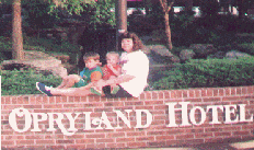 Marie, James and Joshua sitting on the wall in front of the Opryland Hotel