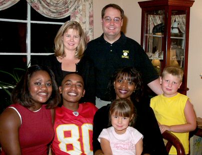 In this family group, Shelly and Tedrick stand in the rear.  Seated, smiling, are Saida on the left, then Abdul, Adidja, Addison, with Madeleine in front of the rest.