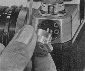 Insertion of the connecting cord plug in battery compartment