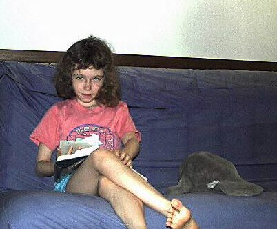 Kathryn reading a Harry Potter book on the couch