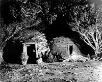 POSED &quotINDIAN CAMPFIRE" IN FRONT OF FRED HARVEY NAVAJO EMPLOYEE HOGANS ADJACENT TO HOPI HOUSE. 14 NOV 1906. PUTNAM & VALENTINE. 