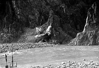 CONSTRUCTION OF RIVER TRAIL BY CCC ENROLLEES. BLASTING ROCK. SEEN FROM  ACROSS RIVER. TRAM CAR ON LEFT. CIRCA 1935. NPS