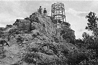 WATCHTOWER CONSTRUCTION SITE. VIEW UP AT WATCHTOWER FRAMEWORK FROM BELOW POINT. PEOPLE STANDING AT POINT. CIRCA 1931. COLTER