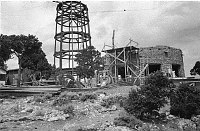 WATCHTOWER CONSTRUCTION SITE. VIEW OF KIVA (MASONRY) AND STEEL FRAMEWORK OF TOWER. CIRCA 1931. COLTER. 