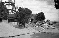 WATCHTOWER CONSTRUCTION SITE. DETAIL - SANDPILE, CONTRACTOR'S SHED, ROCK PILE FOR WALL CONSTRUCTION. CIRCA 1931. COLTER. 