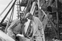 DESERT VIEW WATCHTOWER DURING CONSTRUCTION. TWO MEN WORKING OUTSIDE KIVA PORTION. CIRCA 1932. COLTER. 