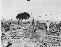 MEN WORK ON WATCHTOWER FOUNDATION. HAUL CEMENT IN WHEELBARROW OVER WOOD PLANKS. CIRCA 1932, HIRCHBORN