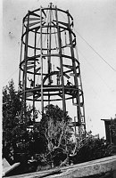 STEEL SKELETON OF WATCHTOWER. WORKERS WAVING. STEEL GIRDERS HANGING FROM CABLES. CIRCA 1932, HIRCHBORN