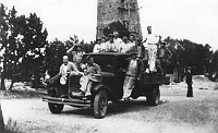 CONSTRUCTION WORKERS STAND ON TRUCK, POSING FOR PORTRAIT IN FRONT OF DESERT VIEW WATCHTOWER. CIRCA 1932, HIRCHBORN