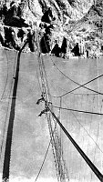 1928 KAIBAB BRIDGE.CONSTRUCTION.  MEN SUSPENDED FROM CABLES OVER COLORADO RIVER. ORIGINAL SWINGING BRIDGE. BELOW. GC 28 L31. 1928. NPS. 