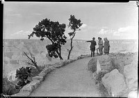 RANGER NATURALIST GUIDING A SMALL PARTY OF VISITORS ALONG THE RIM TRAIL NEAR KOLB STUDIO. CIRCA JULY 1932 NPS PHOTO