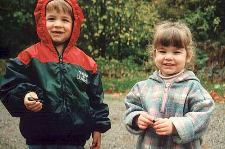 Two smiley kids in the rain