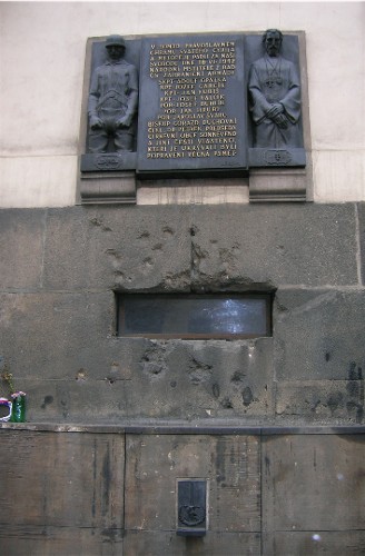 bullet holes and a plaque on the wall of Sts. Cyril and Metodej