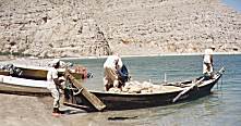 Old fishermen put out to sea in a traditional boat