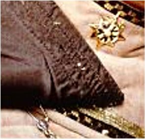 Safety pin holding on a dress medallion