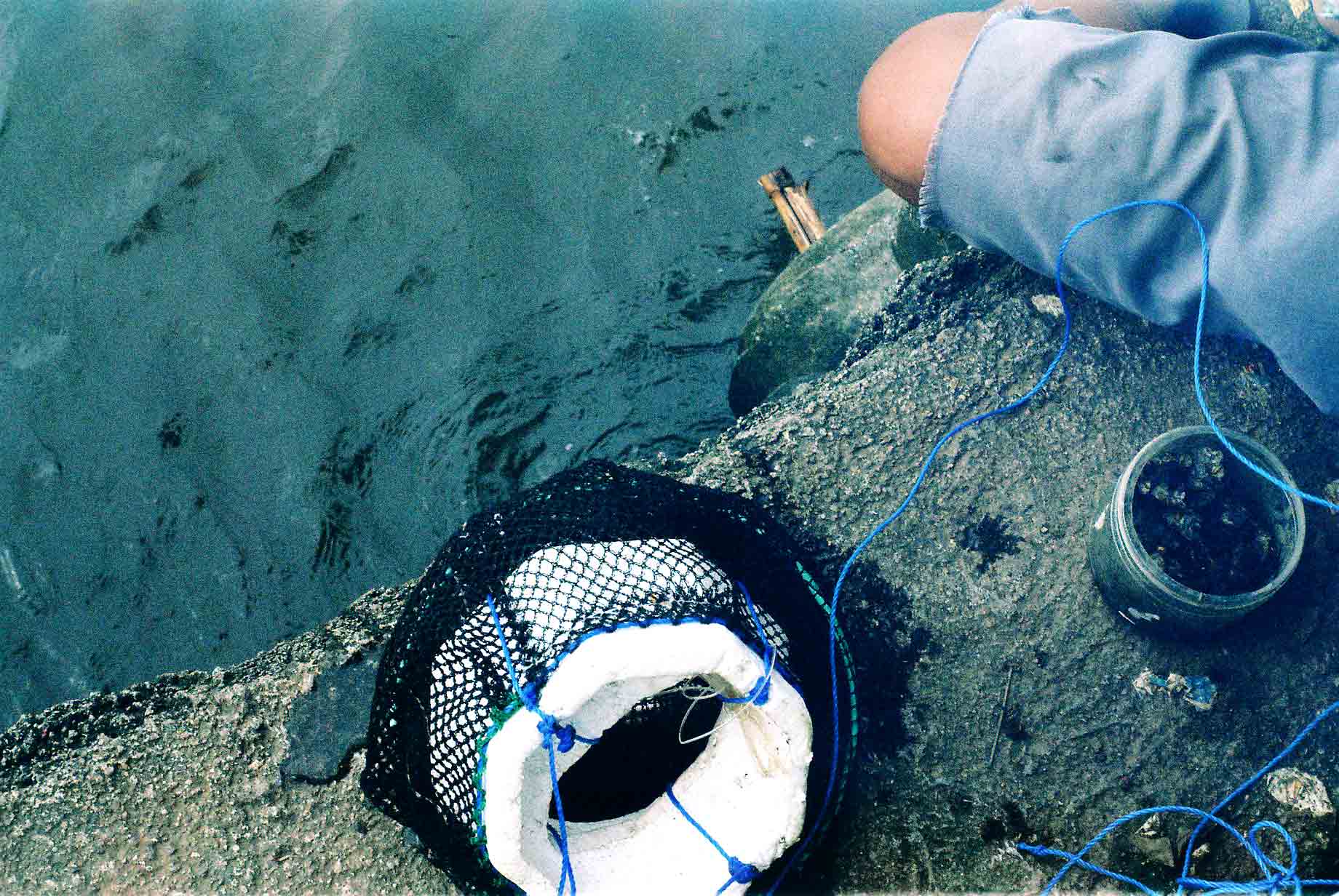 TOOLS OF THE TRADE. A net to contain the catch and a container of worms to bait are just some of the things the fisherfolk at the Laguna Bay arm themselves with.