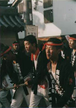 Young men pulling a wagon and looking tired.