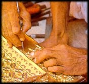 A craftsman at work on brass panel