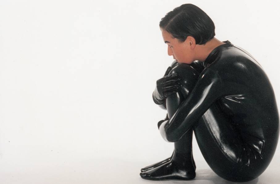 Girl posing in shiny latex catsuit.