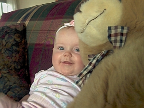 Samantha at the 6 month mark.  She's peaking around her Teddy Bear in this picture.