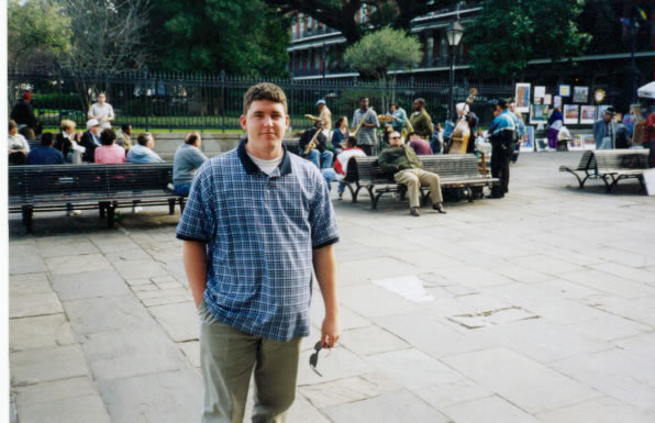 Ty in New Orleans with street band playing in background.