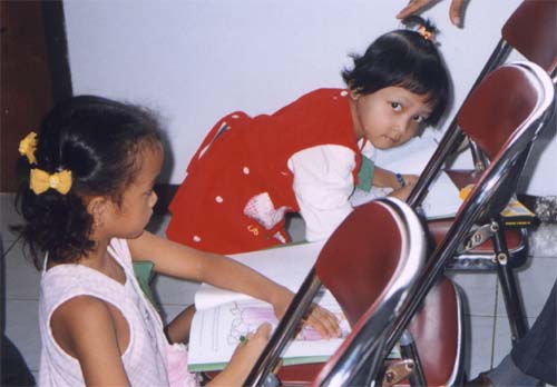 Sarah - girl in red and Putri were drawing their books