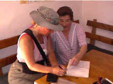 Brigitte firma en el libro de registro bajo la mirada de Mar�a
