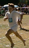 A boy running down a dirt path barefoot