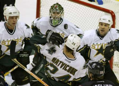 Stu Barnes, Marty Turco, Richard Matvichuk, Mattias Ohlund, and Teppo Numminen all watch the airborne puck