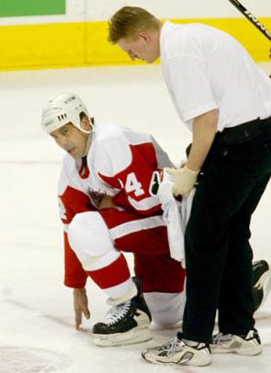 Chris Chelios getting up off the ice after Todd Bertuzzi fell on him after a faceoff (photo by Richard Lam/AP)