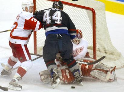 Todd Bertuzzi creates havoc in front of the net with Kris Draper and Manny Legace (photo by Richard Lam/AP)