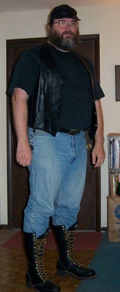 Songdog in leather vest, jeans, lineman boots