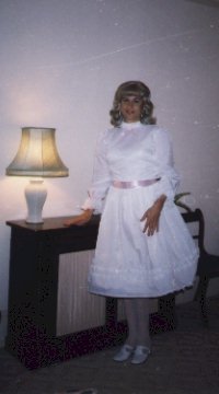 My first party dress, white satin with a pink ribbon tied at the waist