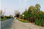 Widok sprzed bramy bylego klasztoru karmelitanek. W oddali narozna wiezyczka straznicza KL Auschwitz.
