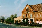 Budynek bylego obozu karmelitanek. W oddali z lewej strony wiezyczka straznicza KL Auschwitz.