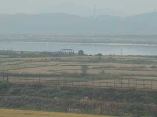 Hazy fences, fields, river, hills